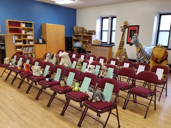 A choir room with no people in it. Stuffed animals sit on each chair.